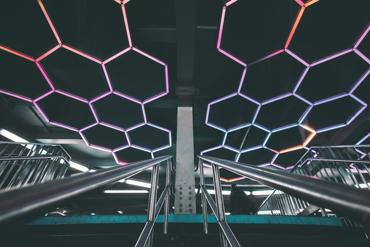 Explore a modern subway station with a futuristic design featuring illuminated geometric patterns and stainless steel railings.